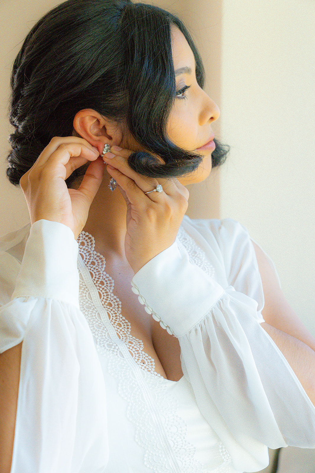 Bride adjusting her earring during a bridal portrait session at Olive Hill Estate in Byron, California.