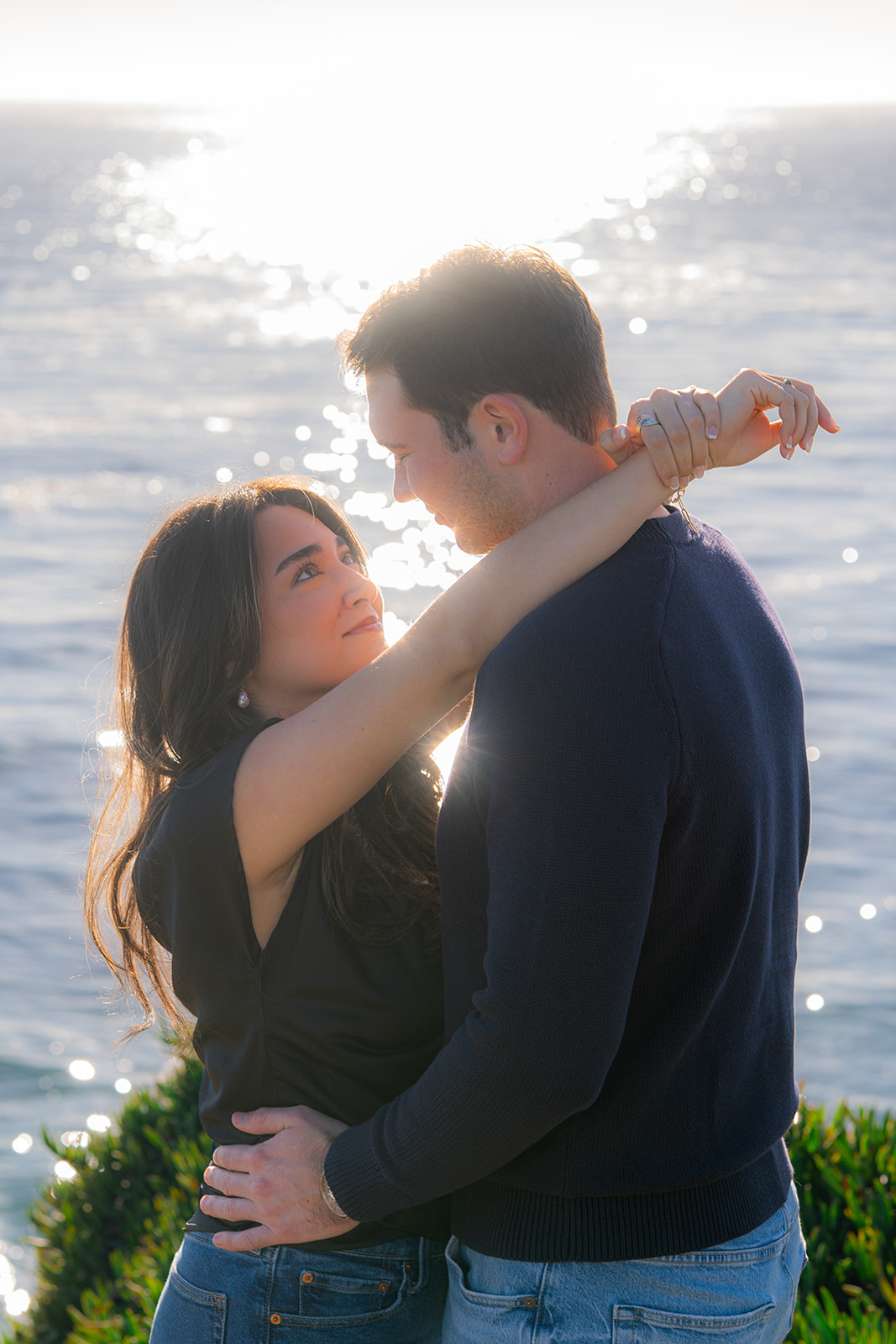 Couple overlooking the sparkling ocean at sunset from a scenic Santa Cruz cliffside.