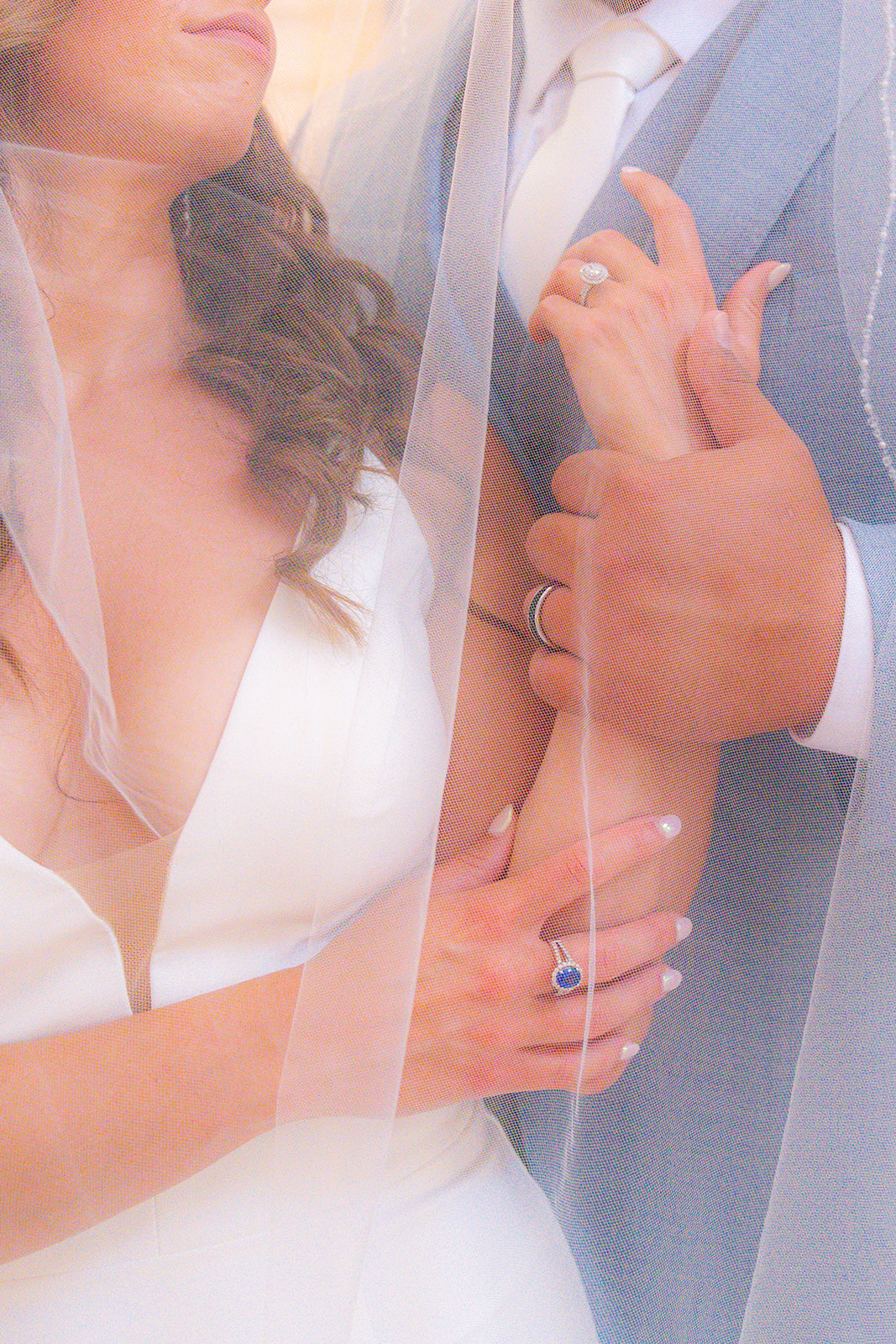 Close-up photograph of a bride and groom together beneath the bride’s wedding veil at San Francisco City Hall.