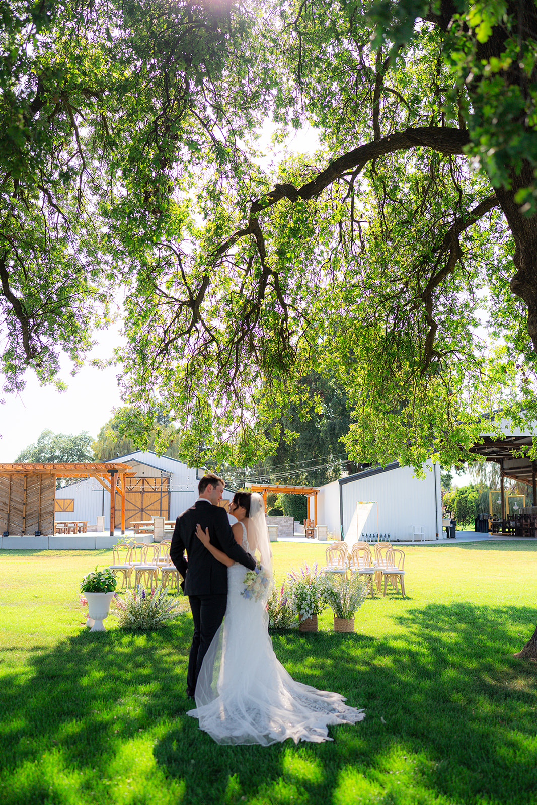 Bride and groom embracing during their wedding ceremony at Rainbow Oaks Ranch in Sanger, California.