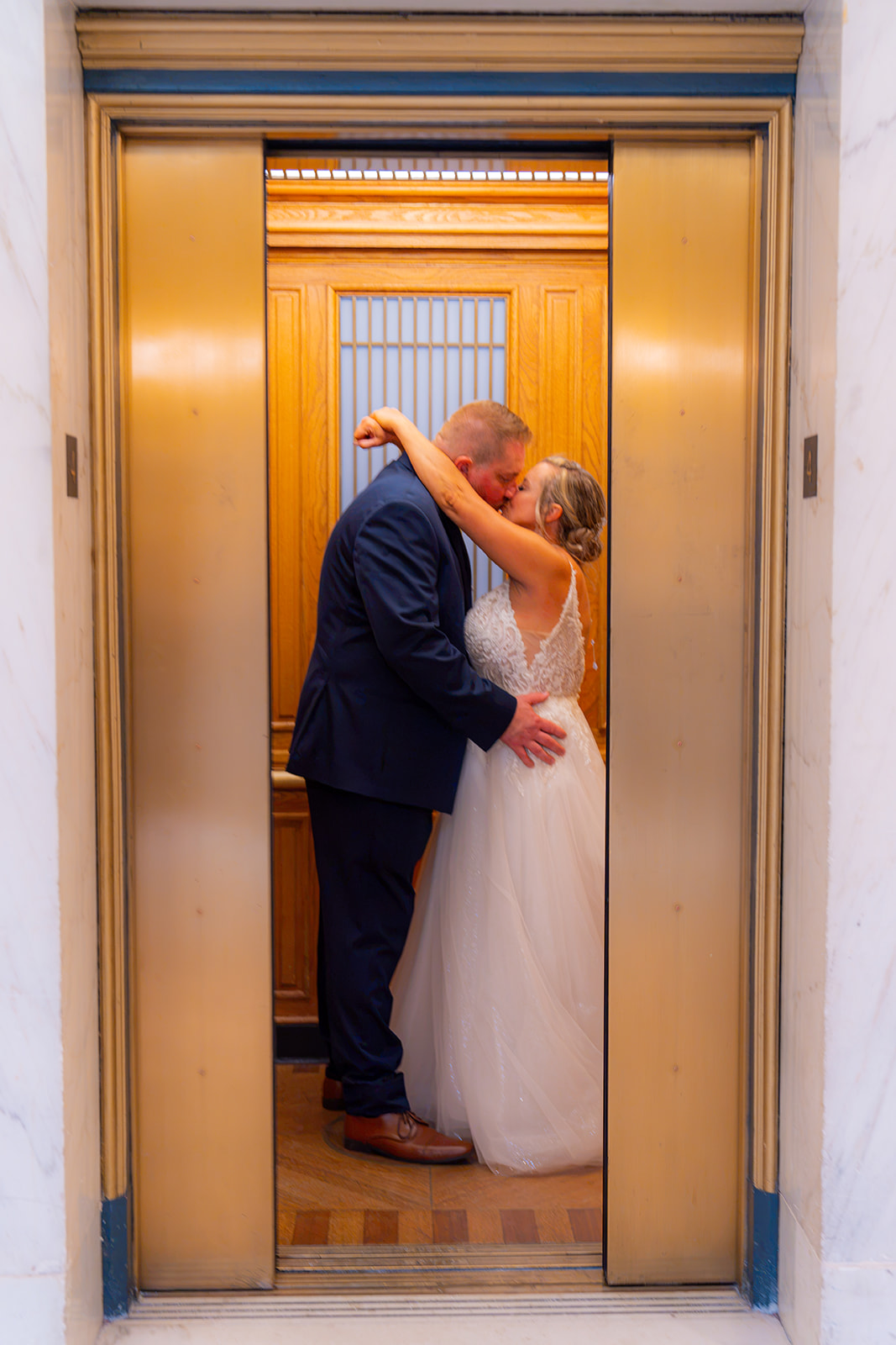 Bride and groom together inside an elevator at San Francisco City Hall on their wedding day