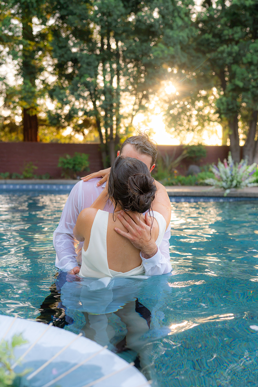 Bride and groom kissing in a swimming pool at Rainbow Oaks Ranch in Sanger, California.
