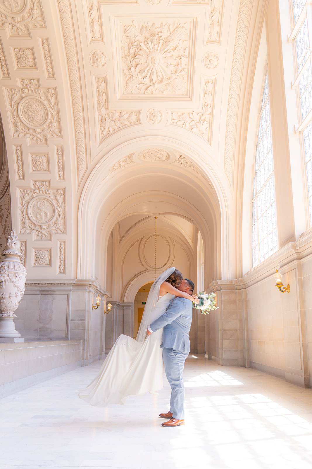 Groom lifting and spinning the bride during their wedding at San Francisco City Hall.