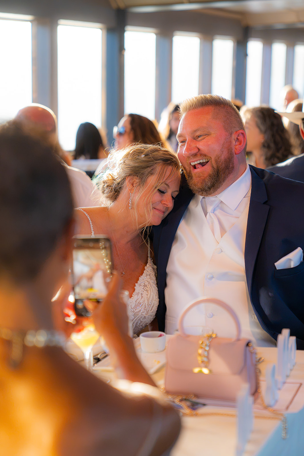 Wedding guest taking a photo of the bride and groom during their cruise reception on the San Francisco Bay