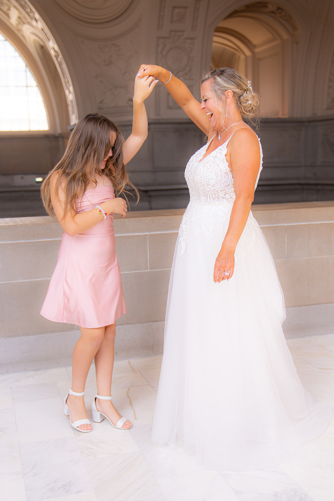 Bride twirling her daughter inside San Francisco City Hall on her wedding day