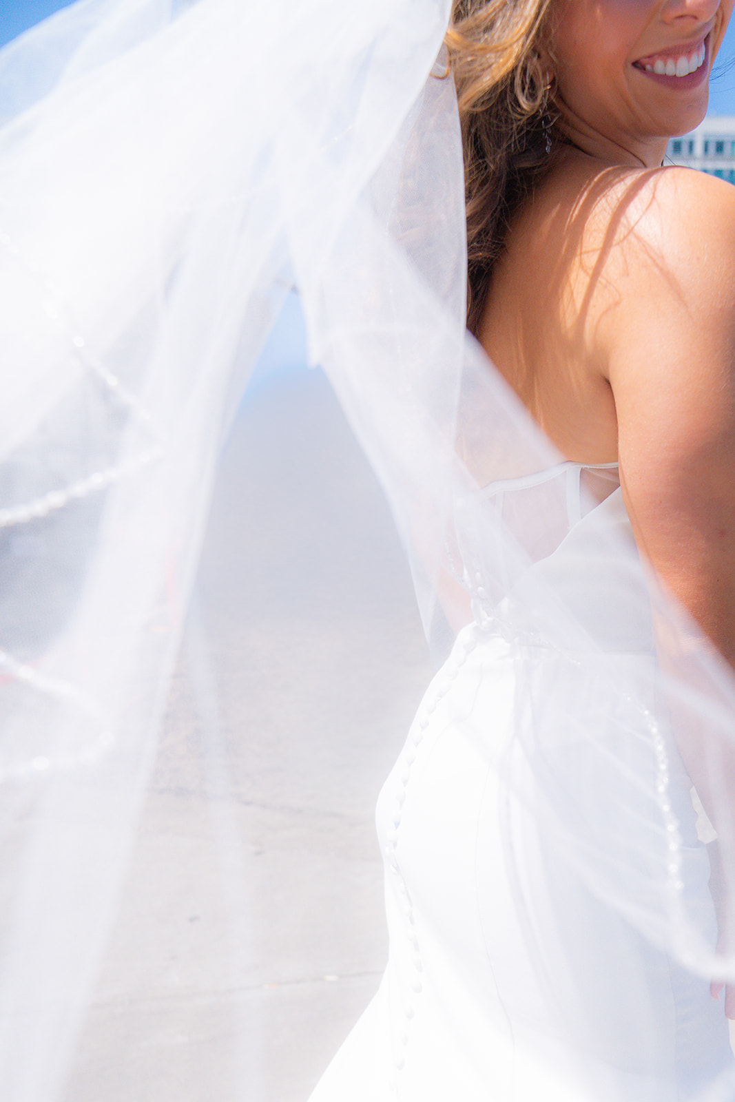 Bride wearing her wedding veil in front of San Francisco City Hall.