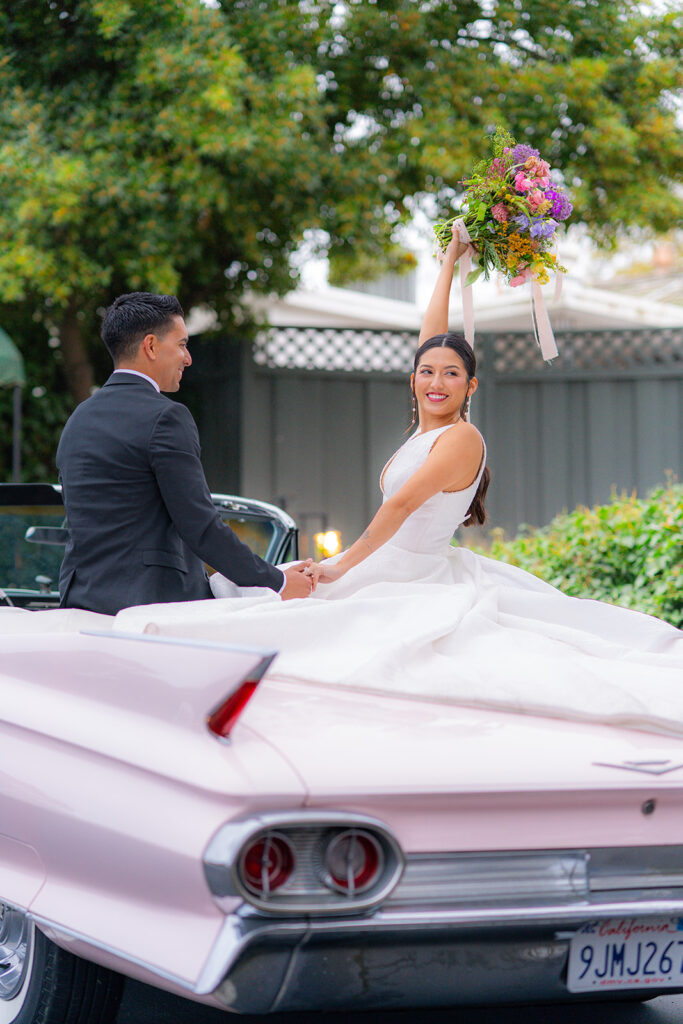 Bride and groom saying goodbye during their wedding exit in a classic car at Hollins House in Santa Cruz, California.