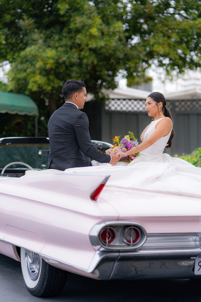 Bride and groom celebrating together beside a classic car at Hollins House in Santa Cruz, California.