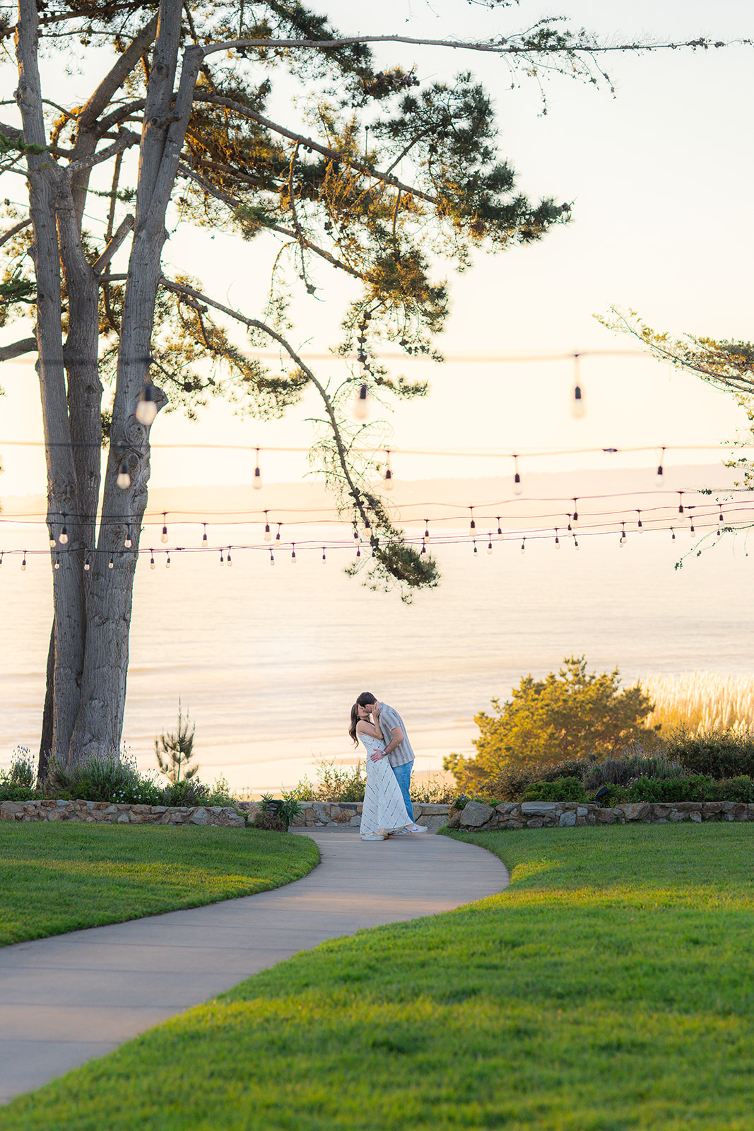 Couple sharing a dip kiss in front of the ocean at sunset at Seascape Beach Resort in Aptos, California.