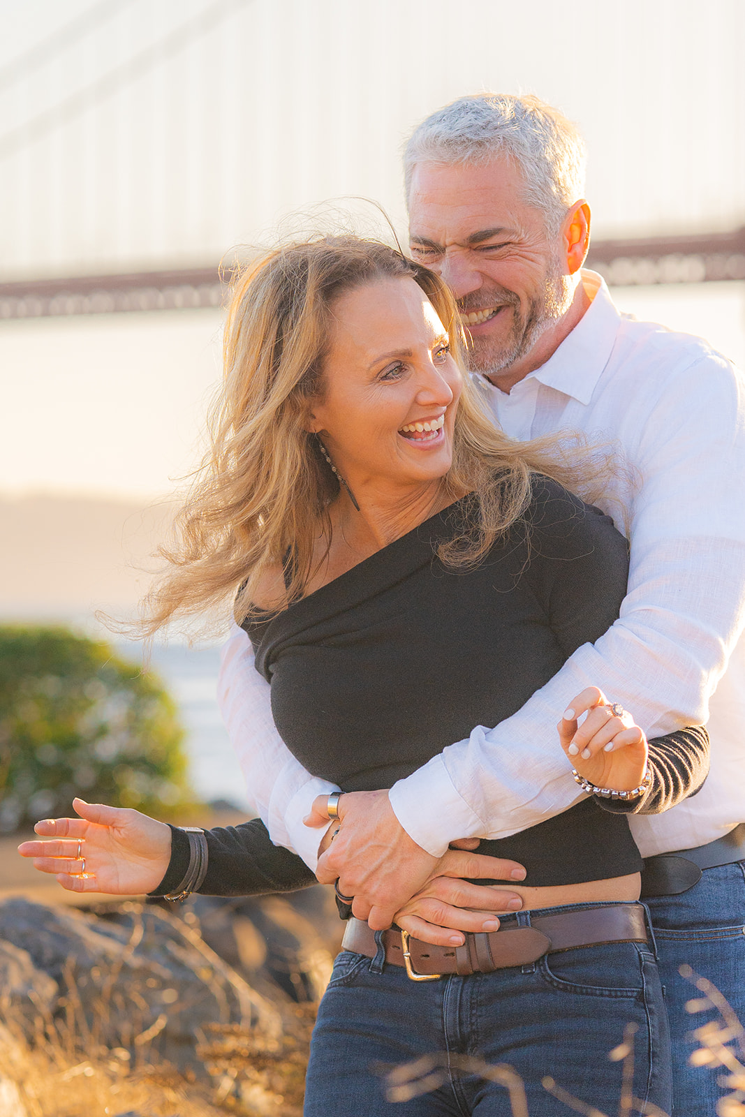 Couple embracing at sunset with the Golden Gate Bridge at Cavallo Point.