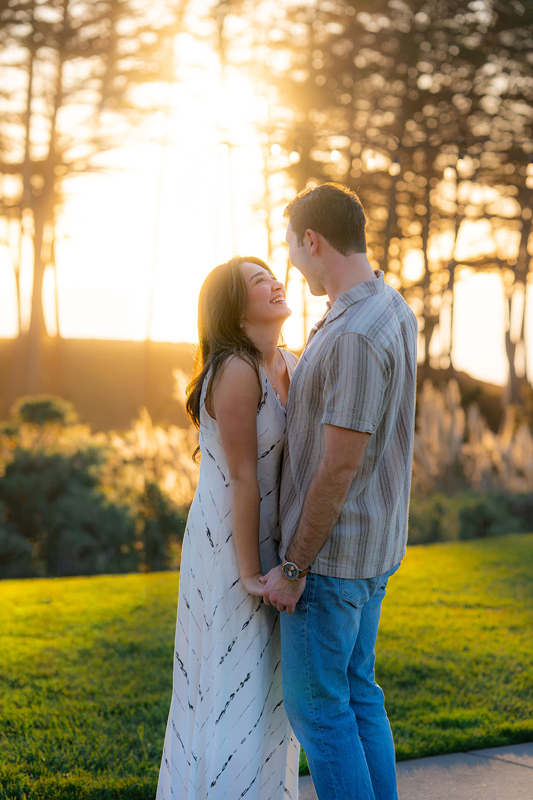 Couple holding hands and laughing during golden hour at Seascape Beach Resort near Santa Cruz.