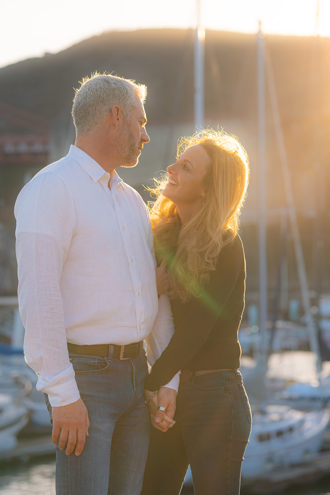Couple laughing by the boats at sunset with the Golden Gate Bridge at Cavallo Point.