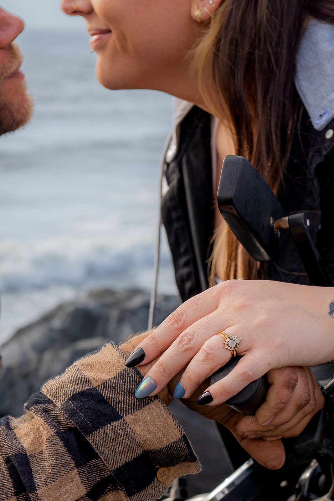 Couple leaning together on a motorcycle during a couples photoshoot at Pacifica State Beach in California