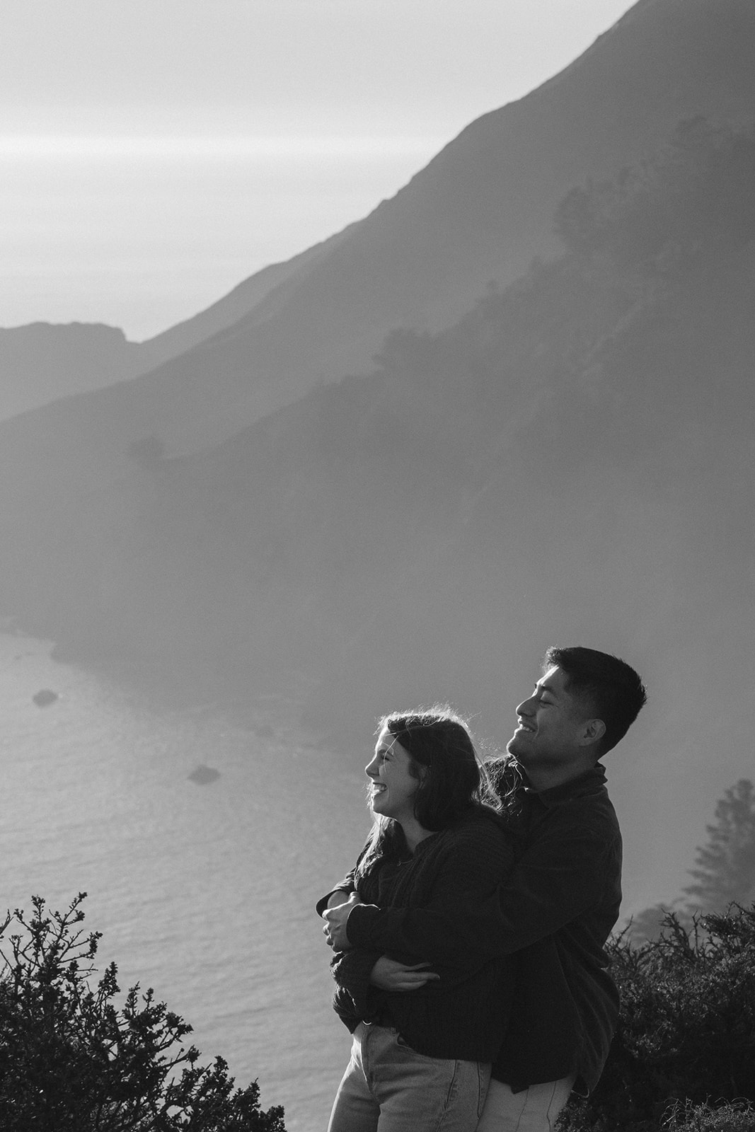 Couple playing together on a scenic cliffside overlooking the ocean near San Francisco.