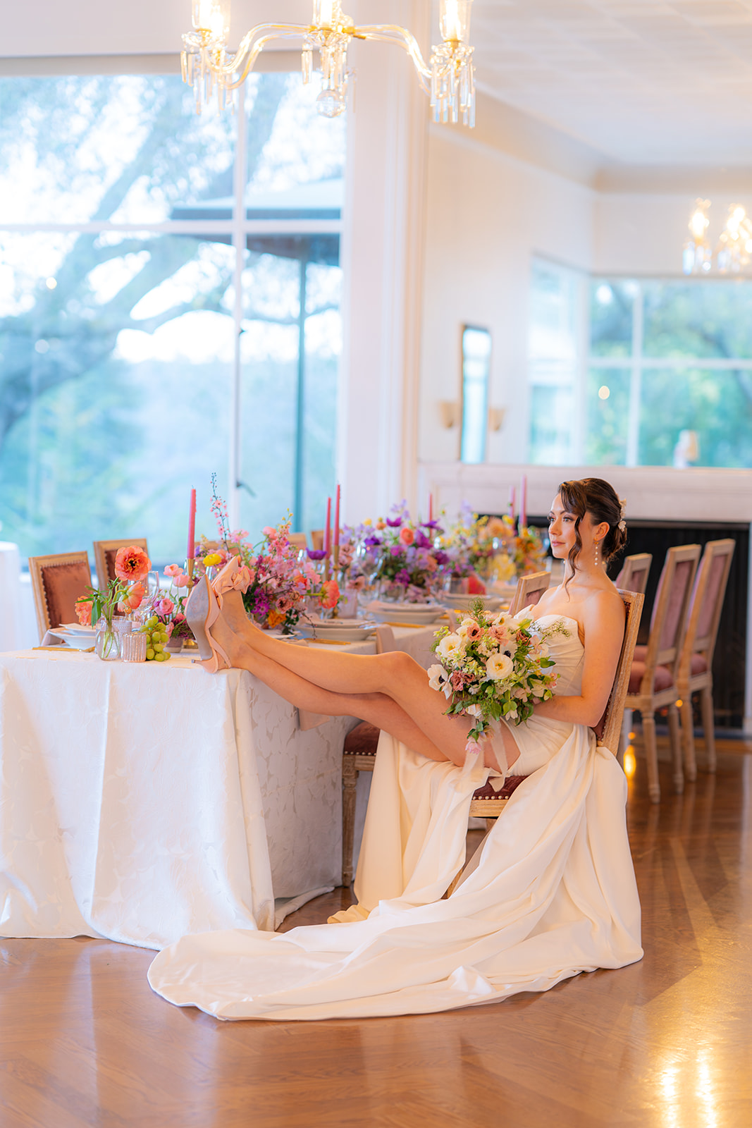 Bride sitting at a wedding reception table and drinking champagne at Hollins House in Santa Cruz, California.
