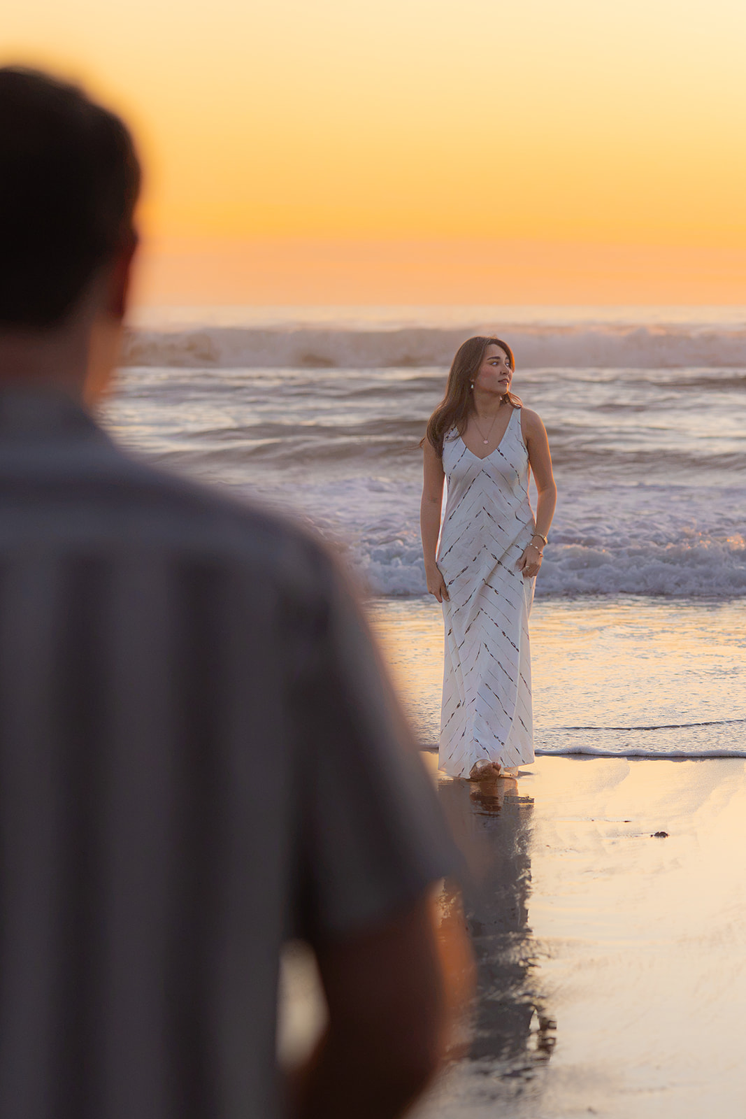 Editorial-style couple on a Santa Cruz beach looking in different directions.