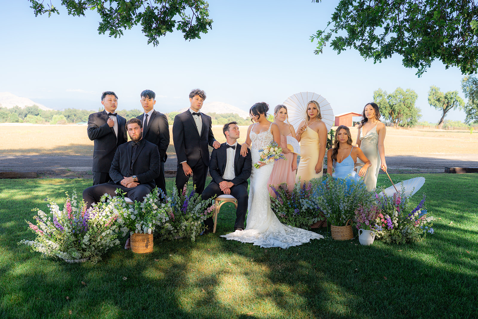 Wedding party posing together for an editorial-style portrait at a garden wedding at Rainbow Oaks Ranch in Sanger, California.