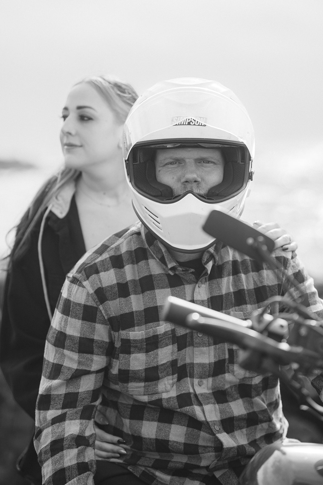 Fashion-forward couple sitting together on a motorcycle during a couples photoshoot at Pacifica State Beach