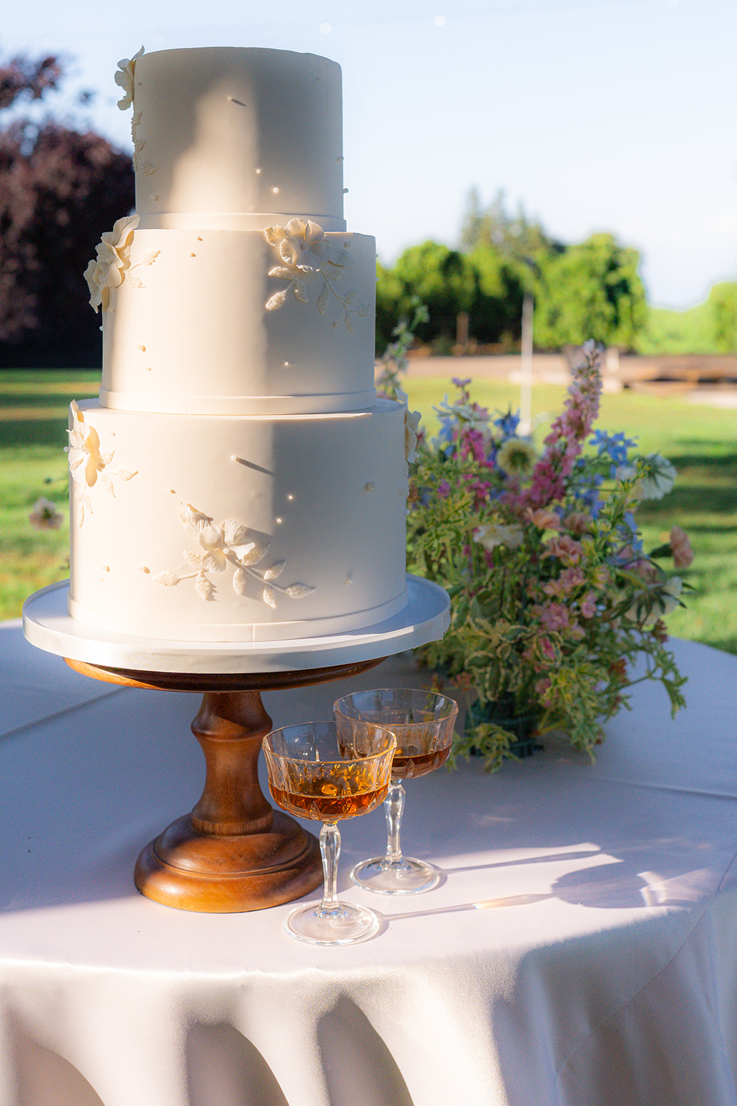 Wedding cake displayed on a table at Rainbow Oaks Ranch in Sanger, California, during a garden wedding.