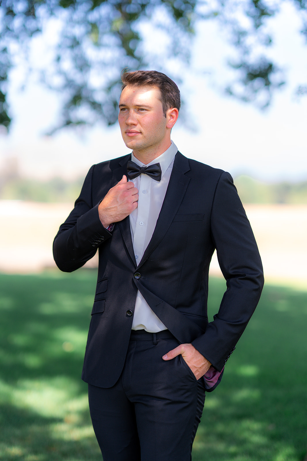 Groom posing beneath a tree at Rainbow Oaks Ranch in Sanger, California.