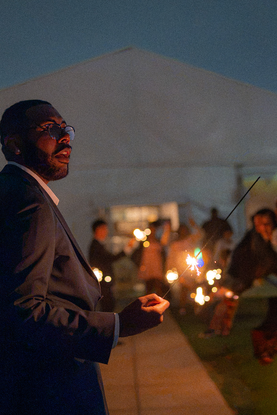 Candid photograph of a groom holding a lit sparkler at Fairview Metropolitan in Oakland, California.