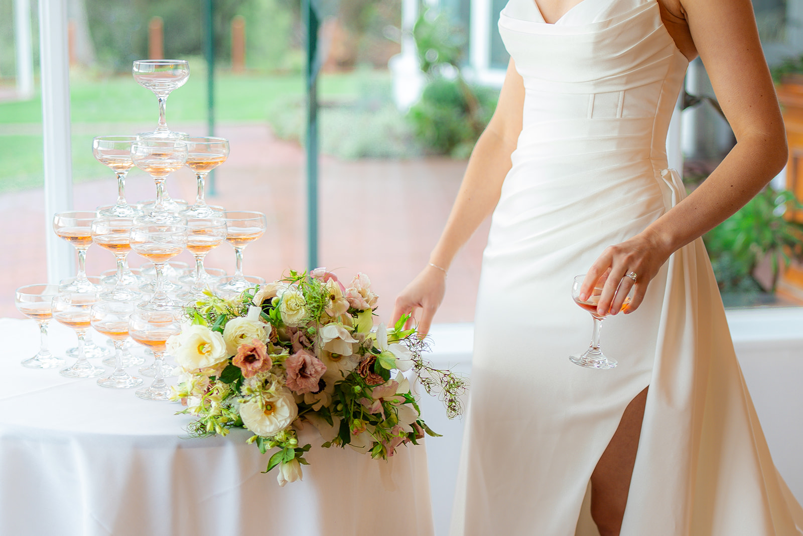 Bride holding her wedding bouquet beside a window at Hollins House in Santa Cruz, California.
