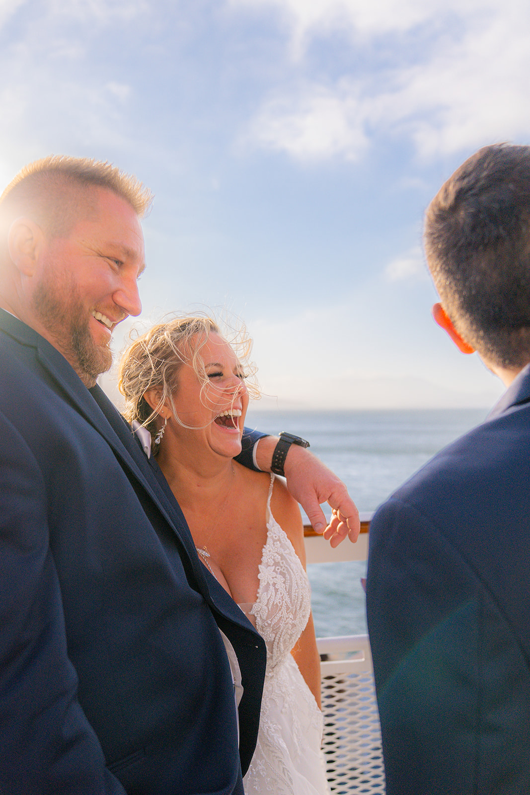 Bride and groom with wedding guests on the deck during a San Francisco cruise wedding reception