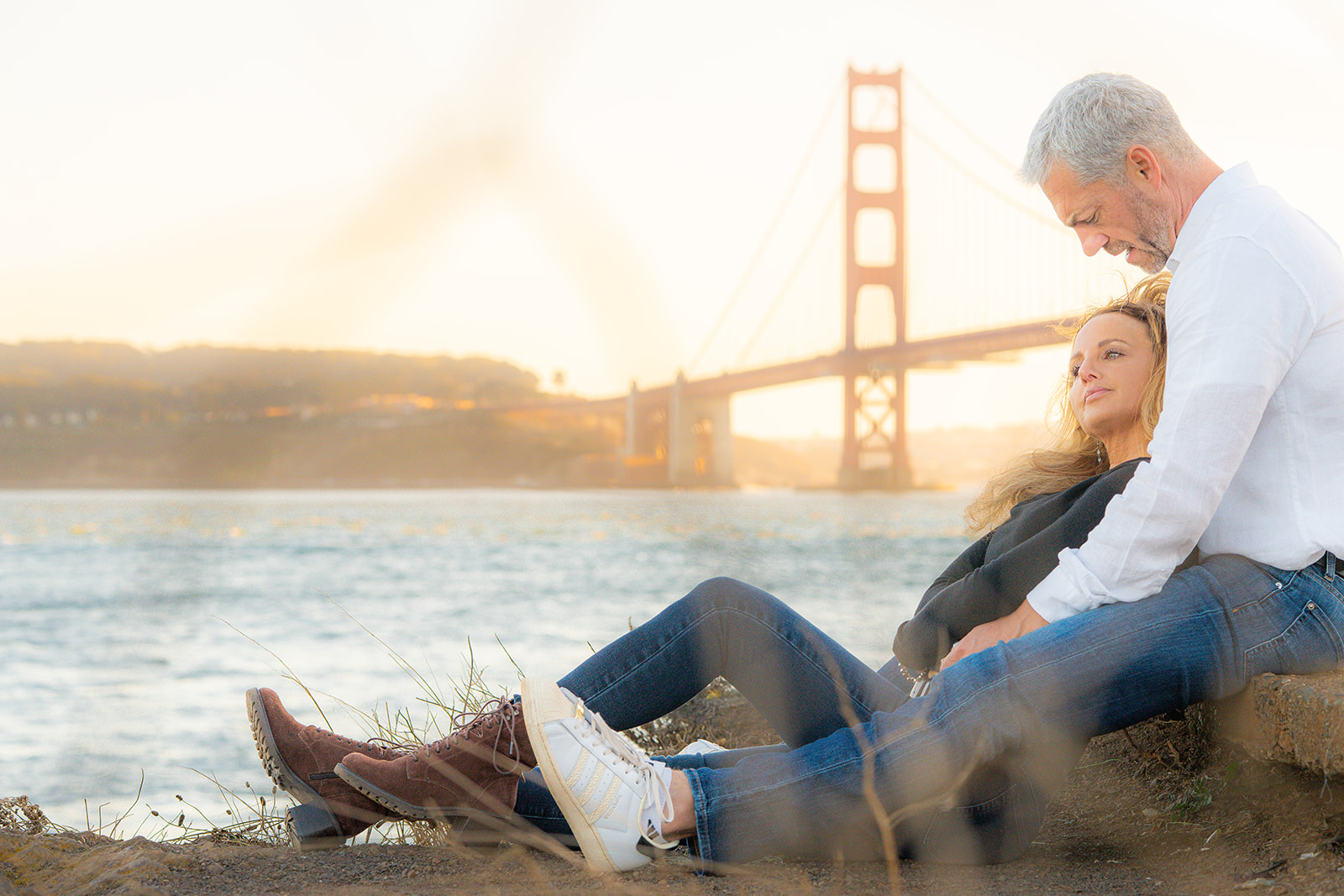 Couple at sunset at Cavallo Point with an iconic view of the Golden Gate Bridge in San Francisco
