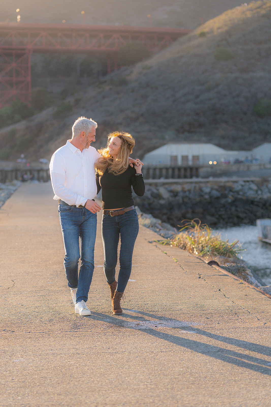Laughing couple at sunset by the San Francisco Bay at Cavallo Point with the Golden Gate Bridge in the background