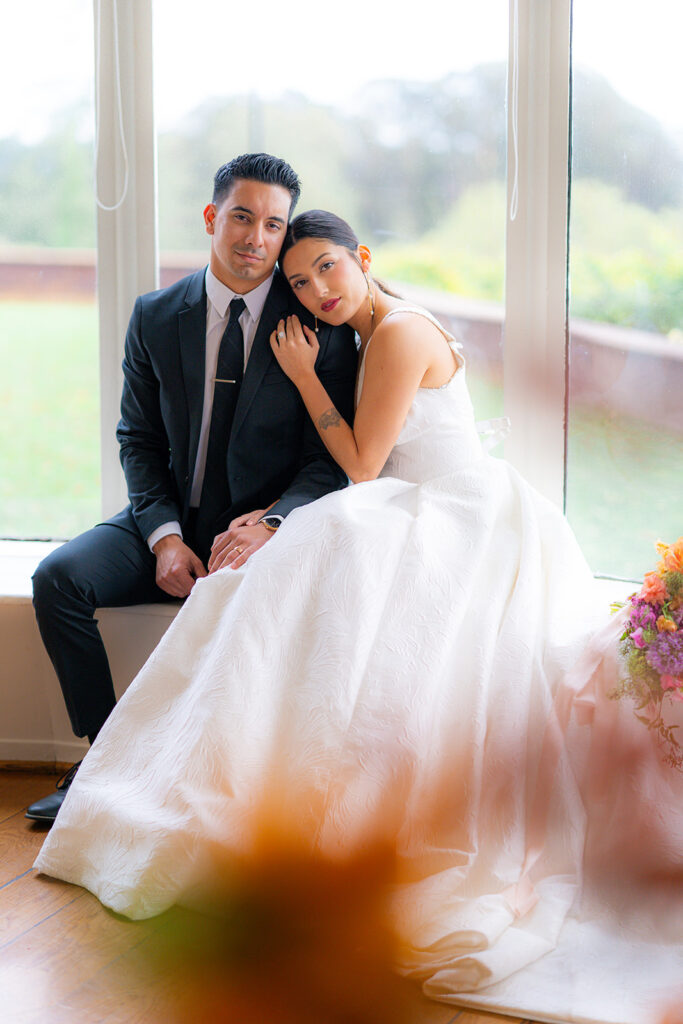 Bride and groom sitting together in a window at Hollins House in Santa Cruz, California.