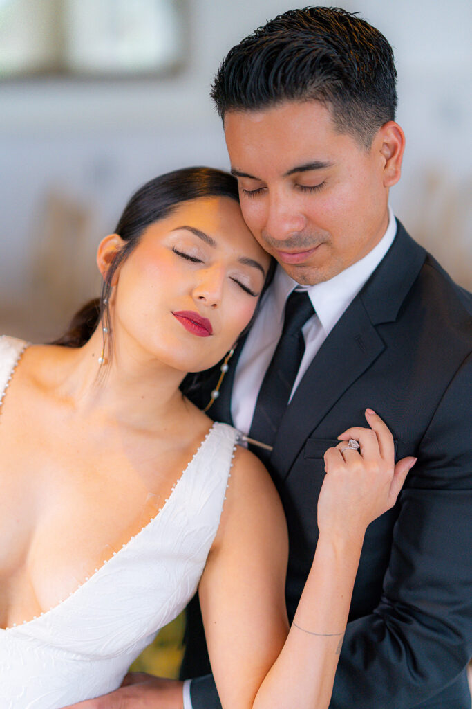 Bride and groom standing together with their eyes closed at Hollins House in Santa Cruz, California.