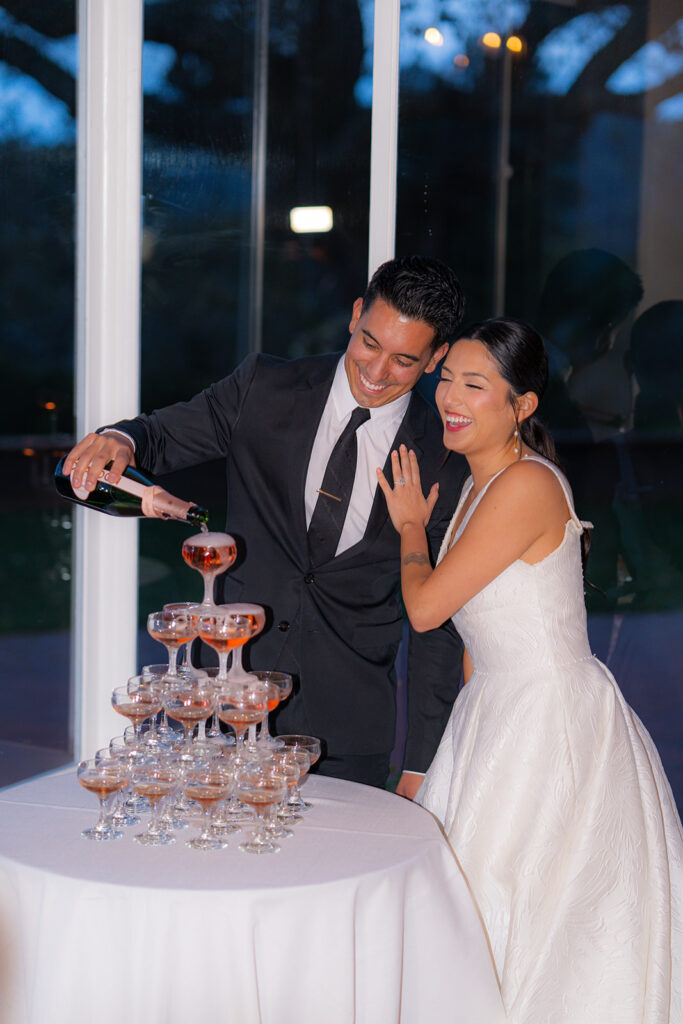 Bride and groom celebrating with a champagne tower at Hollins House in Santa Cruz, California.
