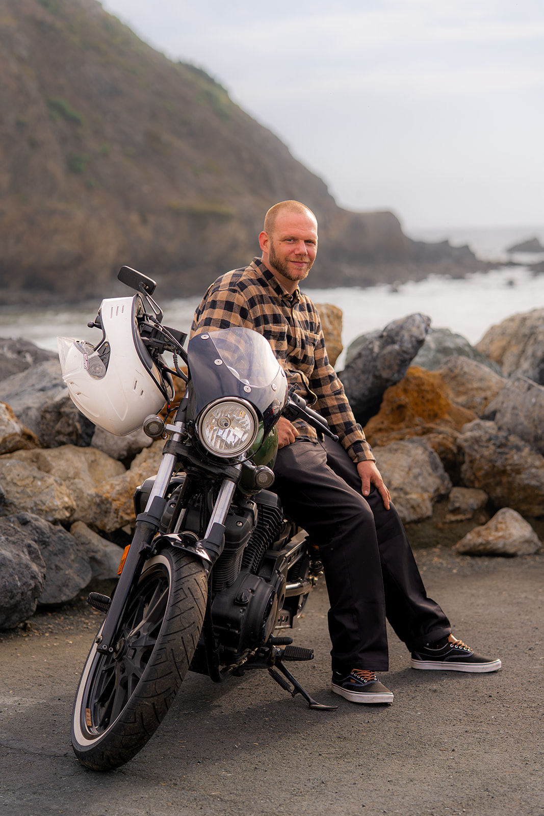 Man sitting on a motorcycle during a couples photoshoot at Pacifica State Beach in California