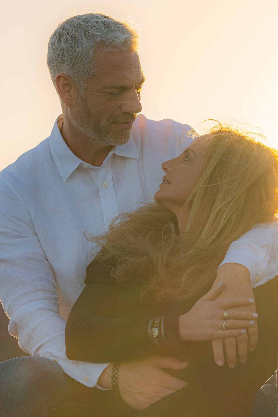 Romantic couple embracing at sunset at Cavallo Point with the Golden Gate Bridge in the background