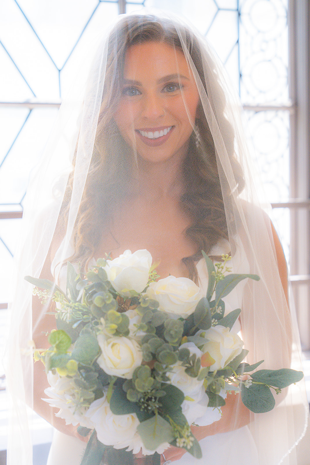 Bride smiling beneath her wedding veil during a bridal portrait at San Francisco City Hall.