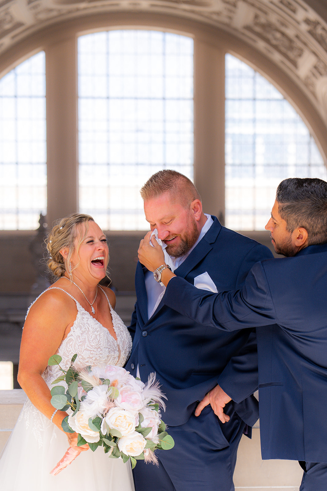 Groomsman wiping tears from an emotional groom during a San Francisco City Hall wedding