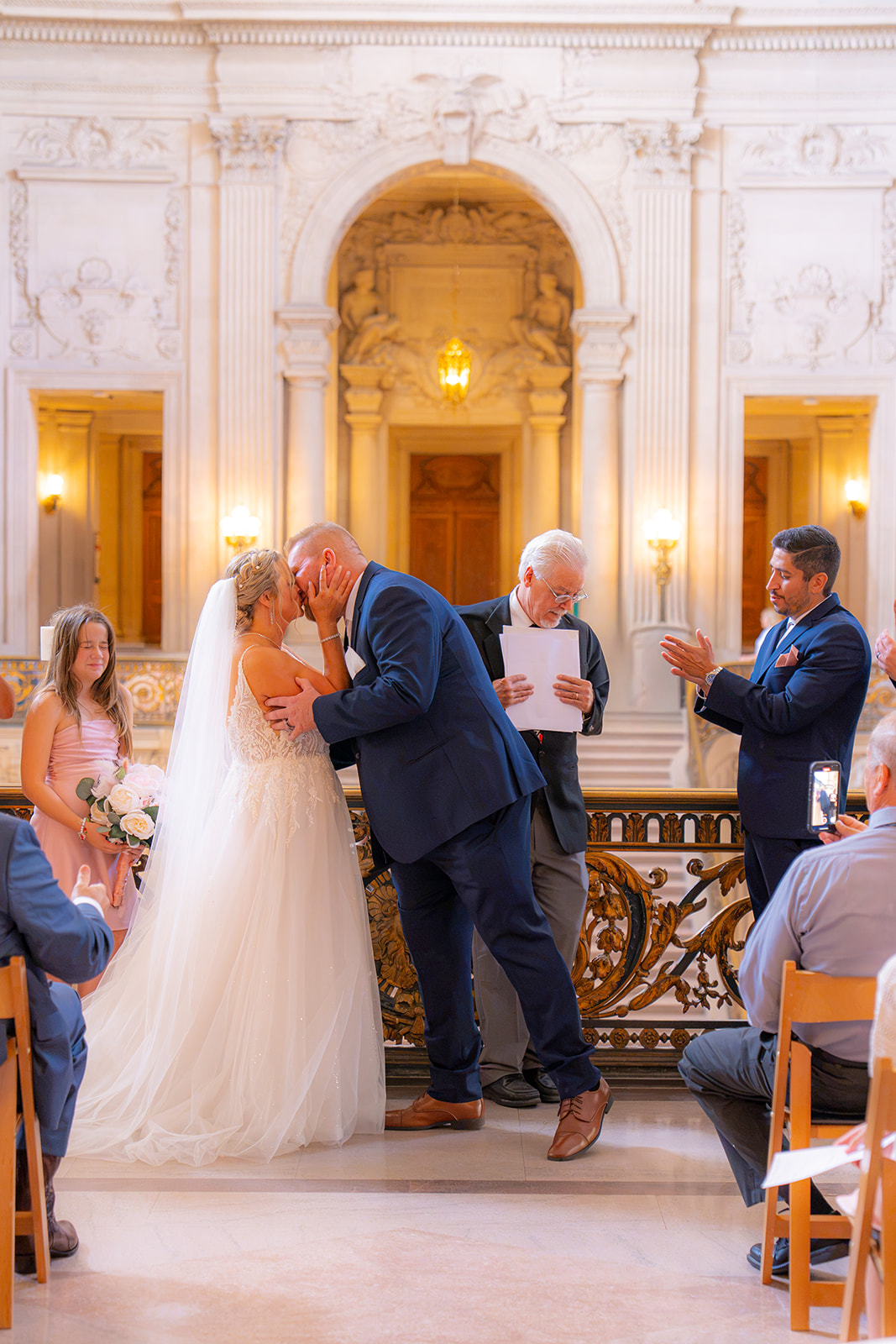 Newlywed couple sharing a kiss during their wedding ceremony at San Francisco City Hall