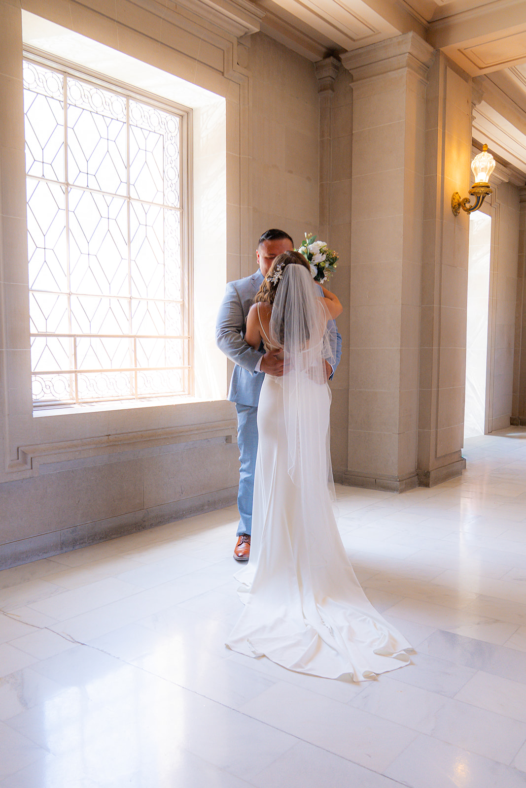 Bride and groom embracing during their wedding first look at San Francisco City Hall.