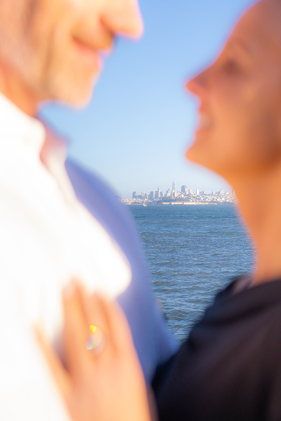 Couple at sunset by the bay at Cavallo Point with the San Francisco skyline in the background