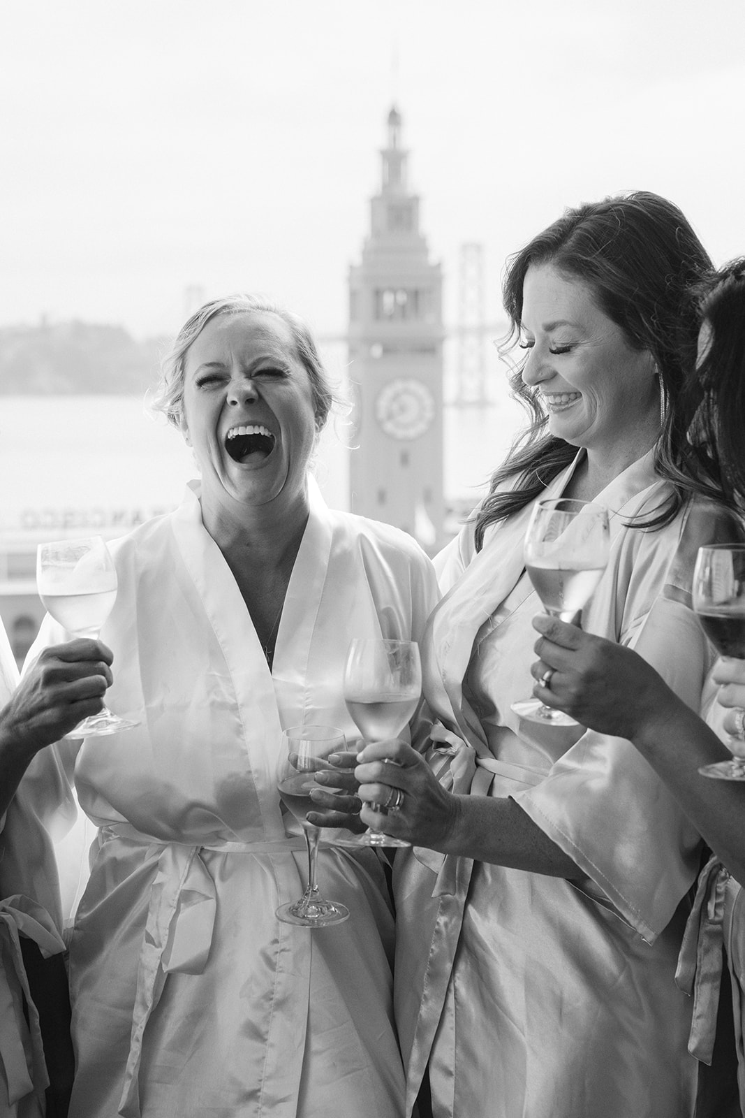 Bride and bridesmaids getting ready together with the San Francisco Ferry Building visible nearby