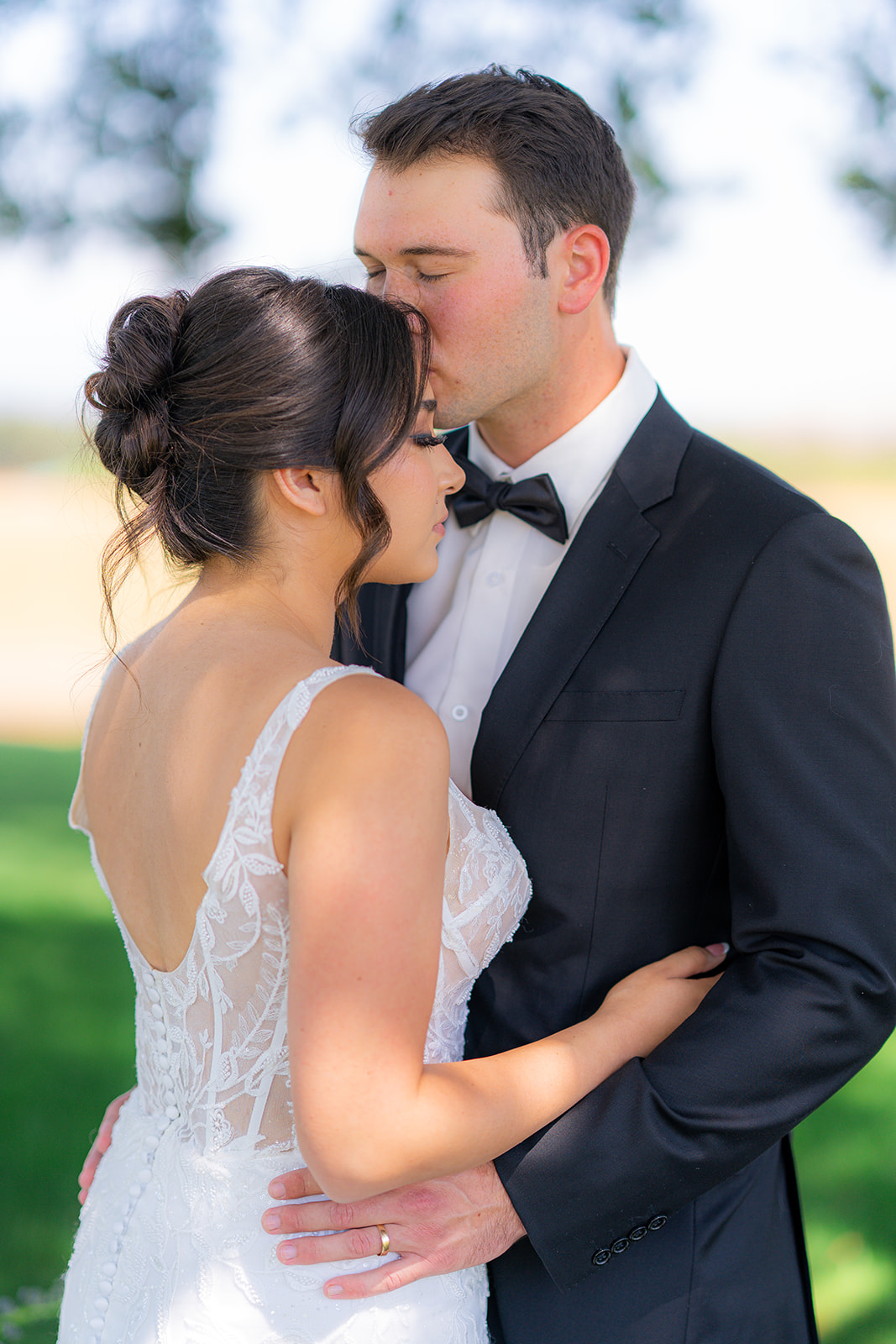 Bride and groom embracing at Rainbow Oaks Ranch in Sanger, California.