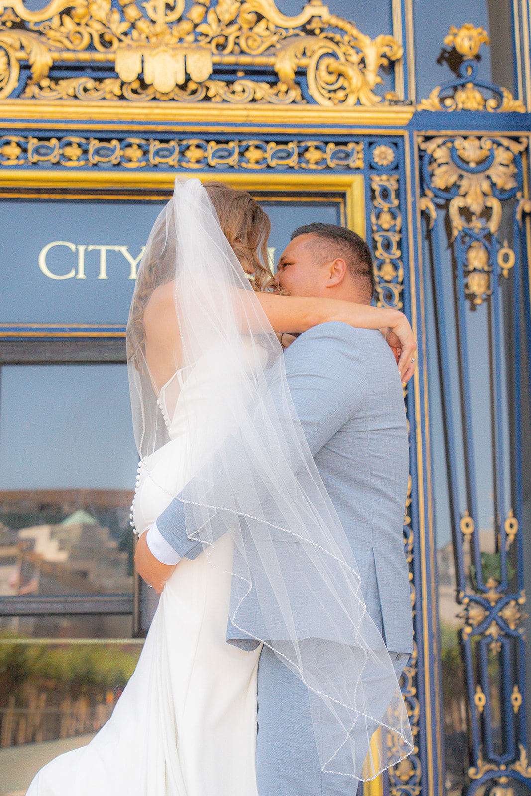 Groom lifting the bride during their wedding exit at San Francisco City Hall in California.