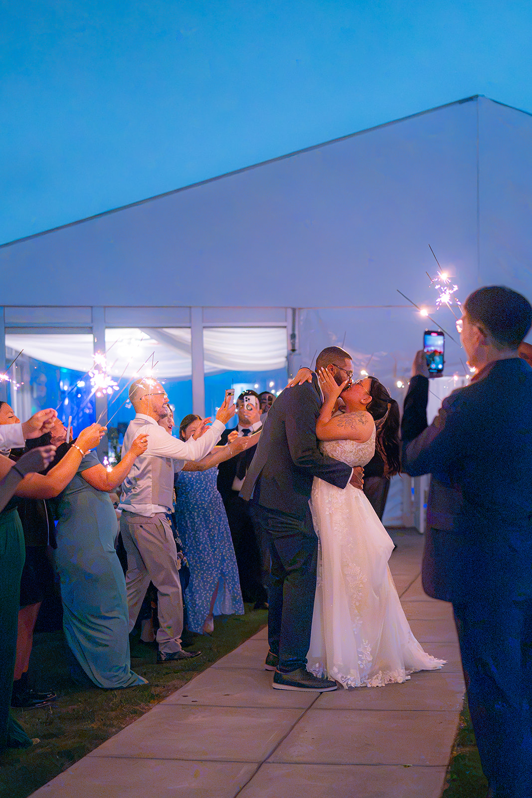 Bride and groom sharing a dip kiss surrounded by sparklers at Fairview Metropolitan in Oakland, California.