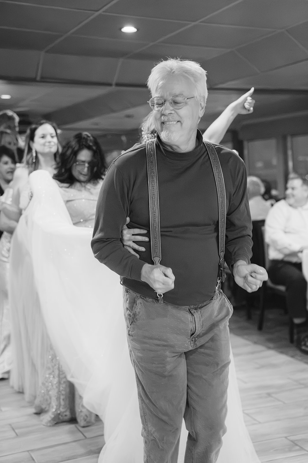 Wedding pastor starting a conga line during a boat wedding reception on the San Francisco Bay